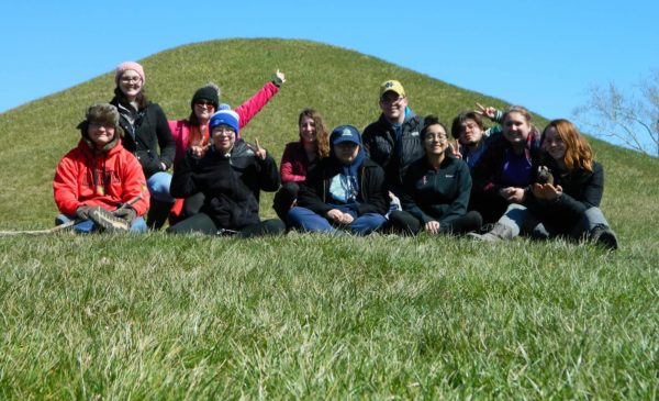 Anthropology Club members in a grassy field while on a fieldtrip