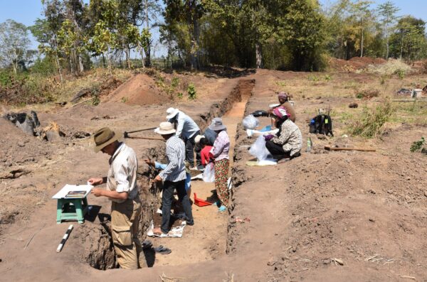 Archaeological team in Cambodia at Tonle Bak in trench excavation drawing wall profiles